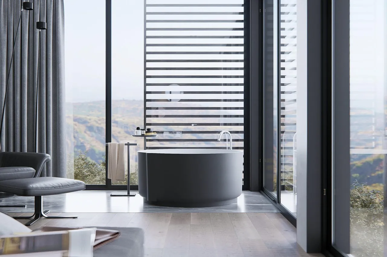 A stone bath looking out over the valley through full-height glass