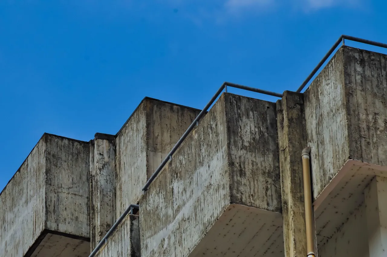 Raw concrete corner against a hard blue sky