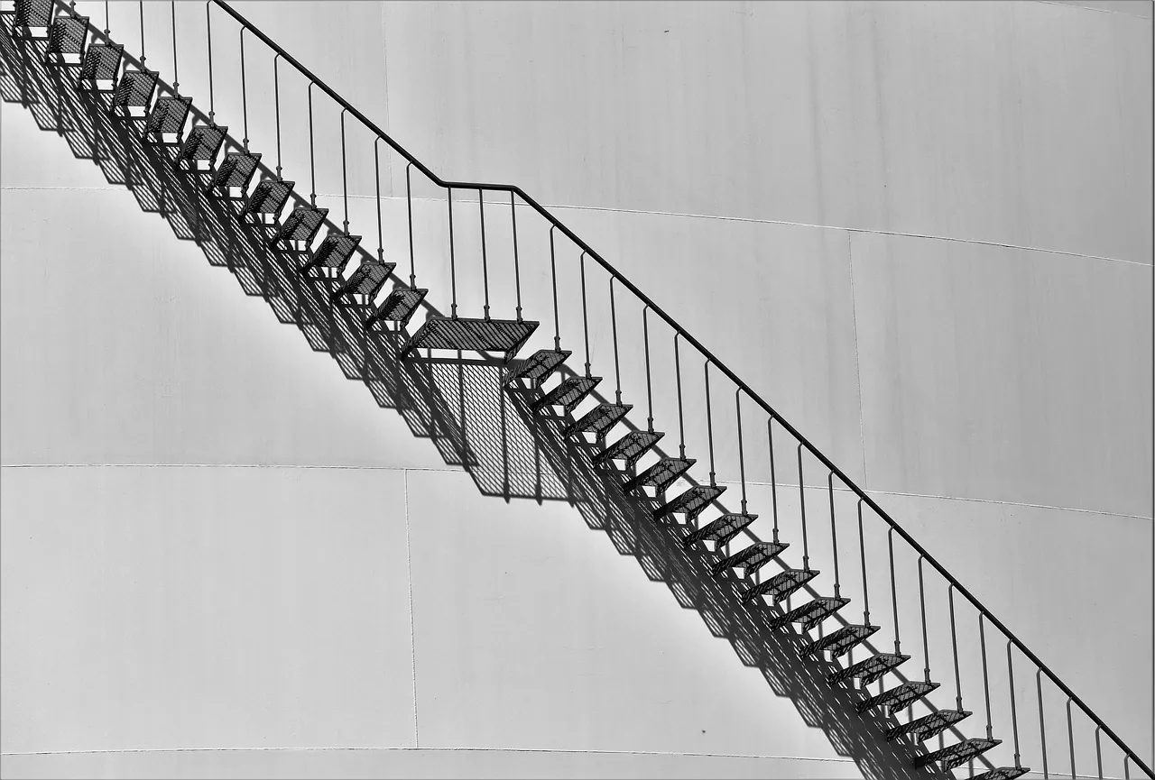A steel stair running diagonally across a blank wall
